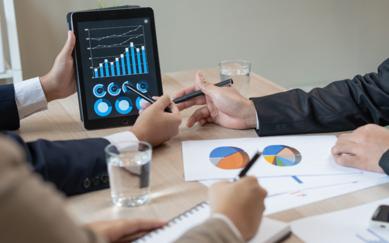 Data is being analyzed on a tablet and paper to define the metrics for effective customer segmentation marketing.